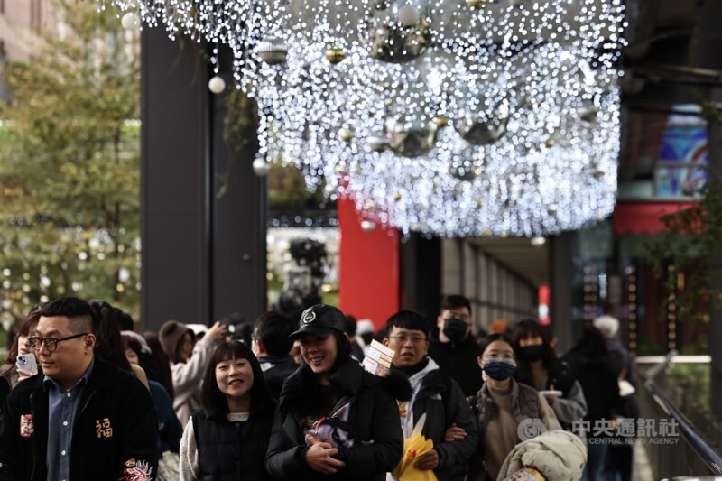 台北市信義區街頭民眾逛街時穿上大衣保暖，感受濃濃耶誕氣氛。（中央社檔案照片）