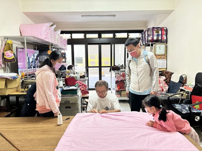新竹市舊城商圈已有70年歷史,市府提供商圈再造輔導計畫,其中60年老店「金德興棉被店」推出手工棉被製作體驗課程,吸引親子家庭參與。(新竹市政府提供)中央社記者郭宣彣傳真 113年12月23日