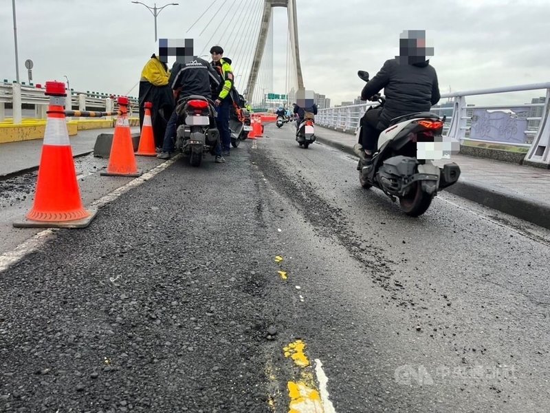 新北大橋正進行機車道改善工程，但瀝青舖設後因天雨導致路面有碎石，24日上午有多名騎士經過時打滑摔車，警方獲報迅速到場交管，施工單位也已完成清理。（翻攝照片）中央社記者王鴻國傳真  113年12月24日