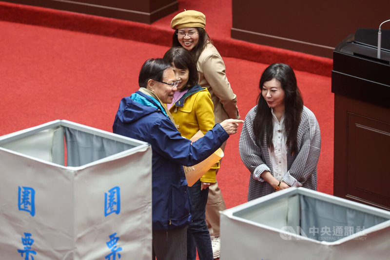 立法院會24日上午進行司法院大法官人事同意權案記名投票表決，民眾黨立委張啓楷（藍衣）圈票後與同黨立委交換意見。中央社記者吳家昇攝 113年12月24日