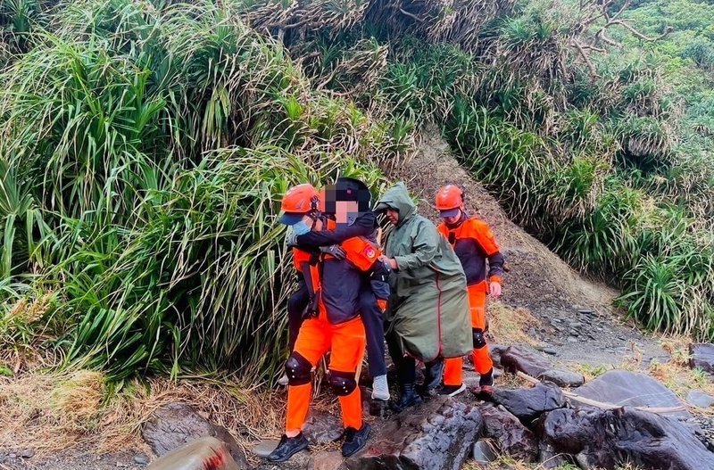 屏東縣牡丹鄉阿塱壹古道23日發生男性遊客失足意外，疑腳底骨折無法行走。海巡人員前往救援，以背負方式通過礫石堆區。（海巡署南部分署第六岸巡隊提供）中央社記者黃郁菁傳真  113年12月24日