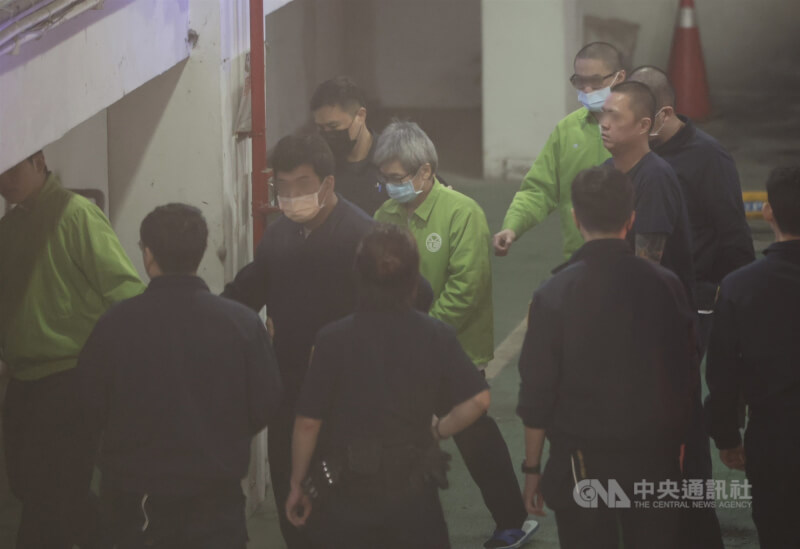 羈押中的前台北市長辦公室主任李文宗(中)戴著口罩、身穿綠色上衣被法警押往北檢。中央社記者趙世勳攝 113年12月26日