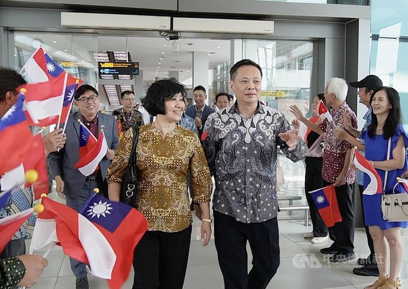 印尼台僑27日在蘇卡諾哈達國際機場揮舞國旗，歡迎駐印尼代表洪振榮（右前）伉儷抵達。中央社記者李宗憲雅加達攝  113年12月27日