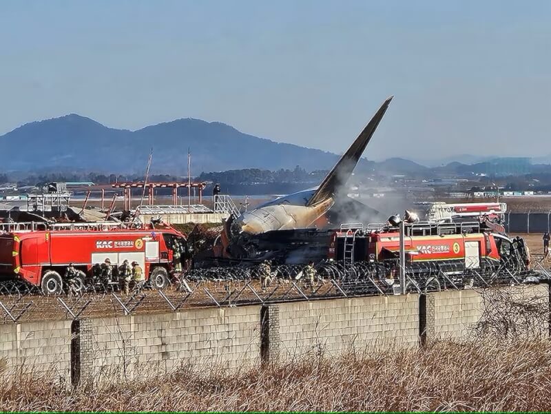 韓國全羅南道務安國際機場29日上午發生飛機降落失事，消防隊替飛機滅火。（韓聯社 via 路透社）