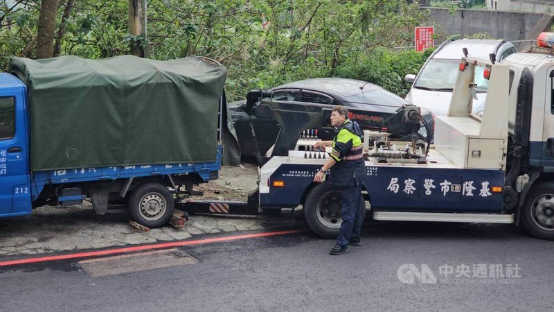 一男子疑遭殺害，被裝在冰櫃內搬運至貨車，連人帶車被棄置在基隆市信義區培德路，警方30日尋獲運屍貨車，發現遺體已被燒成焦黑，難以辨別面容。圖為警方派員將貨車拖離現場。中央社記者王朝鈺攝  113年12月30日