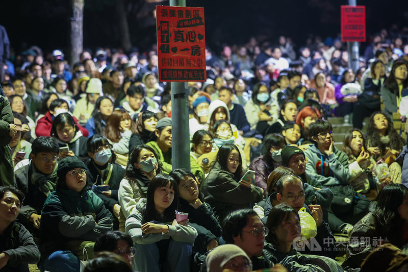 「在大安森林（公園）一邊哭一邊跨年」活動31日晚間在台北大安森林公園登場，大批民眾齊聚欣賞導演蔡明亮經典電影「愛情萬歲」，現場燈桿上還貼有趣味小廣告。中央社記者王騰毅攝 113年12月31日