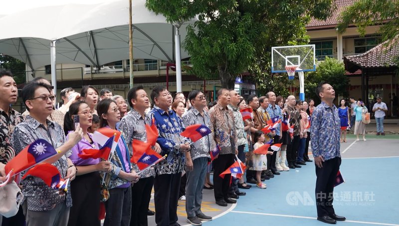 近百名僑胞和台商手拿中華民國和印尼國旗，齊聚在印尼雅加達台灣學校操場，並在駐印尼代表洪振榮的帶領下，合唱國歌與國旗歌。中央社記者李宗憲雅加達攝  114年1月1日