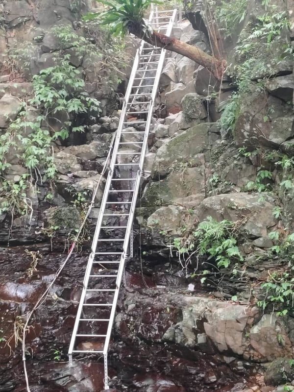 新北市山區簡易自來水管線如有狀況,多需仰仗巡水員揹管搶修,早年得靠拉繩攀爬的陡峭山壁,水利局後來加設維修爬梯,提升安全度。(水利局提供)中央社記者王鴻國傳真 114年1月2日