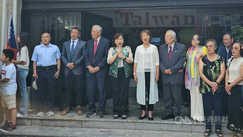 駐阿根廷代表謝妙宏(圖中持麥克風者)在元旦升旗典禮帶領僑民們一同清唱中華民國國歌,僑民們也齊聲高唱,看著國旗升起,氣氛感人。中央社記者黃韻如布宜諾斯艾利斯攝 114年1月3日