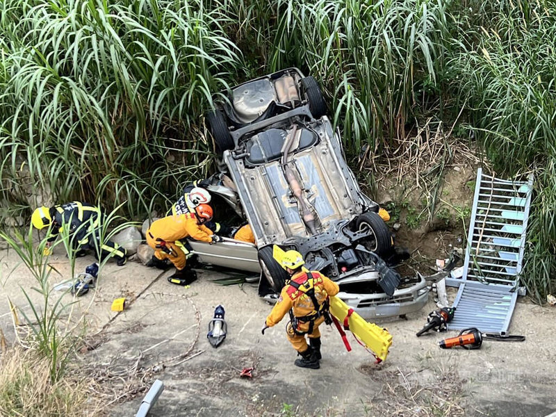 陳姓男子9日駕駛自小客車，在台中市北屯區一處路口與周男駕駛搭載周女的車輛發生碰撞，周男車輛偏移衝入廍子溪邊坡翻覆，警消人員獲報到場搶救。（翻攝照片）中央社記者蘇木春傳真  114年1月9日