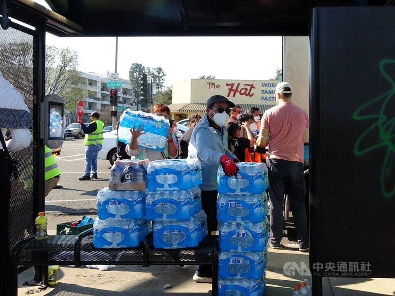 洛杉磯野火災情嚴重,來自各界捐贈的民生物資湧入災區,一箱箱的飲用水堆滿公車亭。中央社記者林宏翰洛杉磯攝 114年1月12日