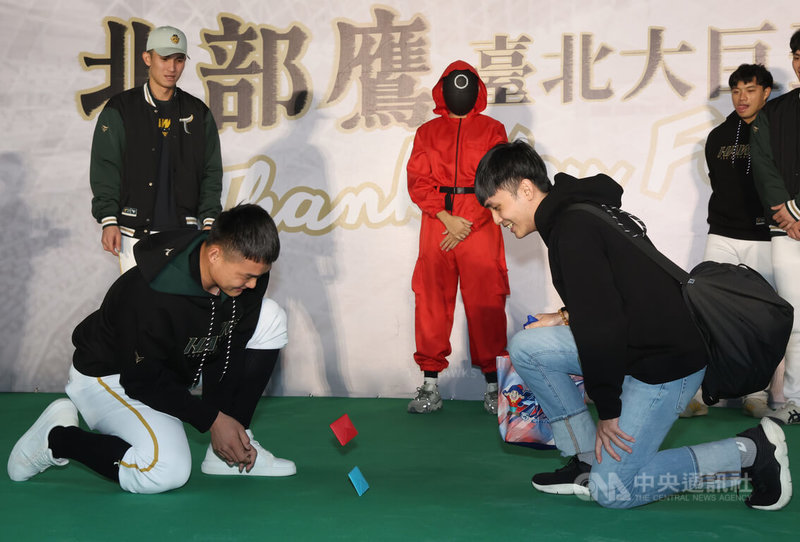 中職台鋼雄鷹隊12日在台北大巨蛋舉辦簽名會,球員陳文杰(後左)、陳柏清(前左)與球迷互動玩遊戲。中央社記者張新偉攝 114年1月12日