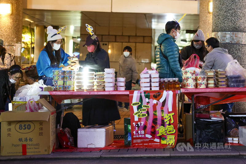 社團法人人生百味文化建構協會從2015年起發起街頭尾牙行動，2025年活動17日晚間暖心登場，多名工作人員現場忙著整理各式愛心餐點。中央社記者王騰毅攝  114年1月17日