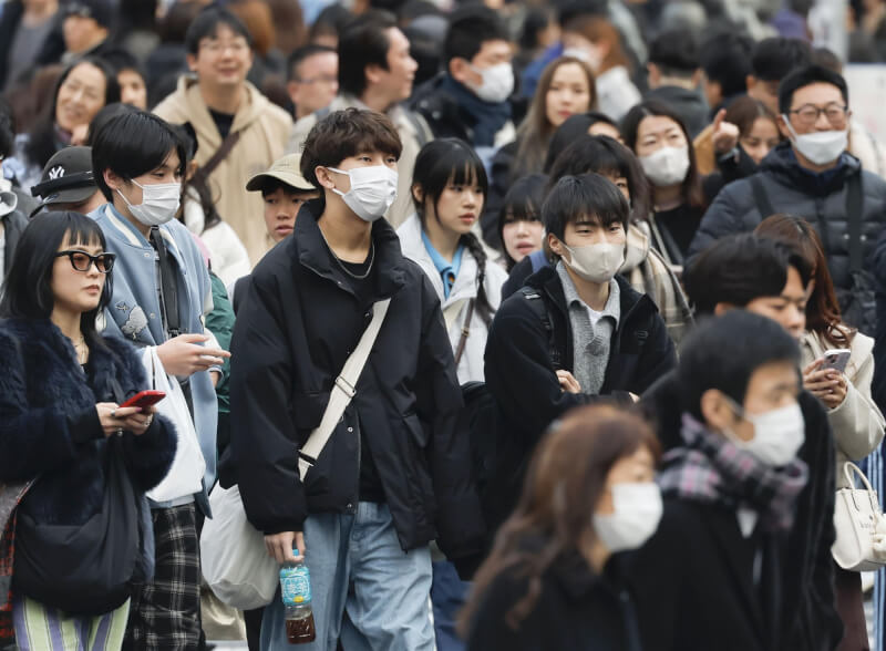 日本流感疫情持續流行，12日東京澀谷街頭民眾戴口罩。（共同社）