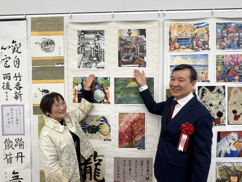 第22屆「美超越國界」國際水墨展於23日在東京國立新美術館開幕,駐日代表李逸洋與促成台灣作品參展推手之一的醫師中山玉惠於台灣展區兒童作品前合影。(文化部駐日台灣文化中心提供)中央社記者戴雅真東京傳真 114年1月23日