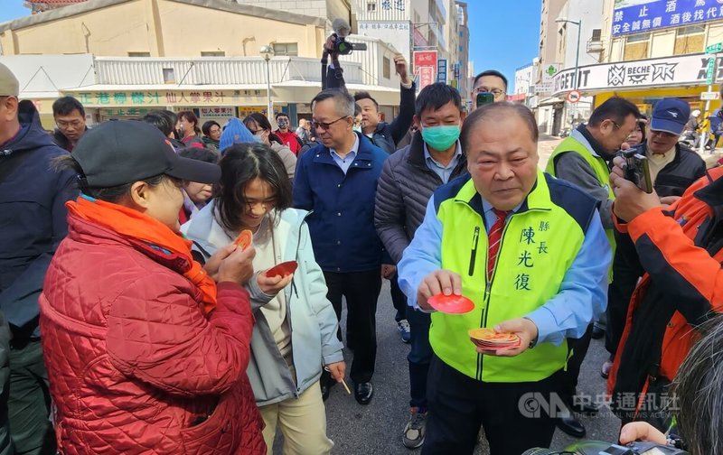 農曆大年初一,陽光露臉,澎湖縣長陳光復(前右)29日到馬公城隍廟前廣場發放福袋,吸引許多民眾到場領取,福袋很快就被索取一空。中央社 114年1月29日