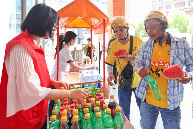 近期中國北京、上海、廣州、天津、成都等城市，有店家開始提供免費餐點給外送員、失業者。圖為2024年8月7日，南京一街道工作人員贈送外送員、環衛工免費飲料。（中新社提供）中央社  114年2月1日