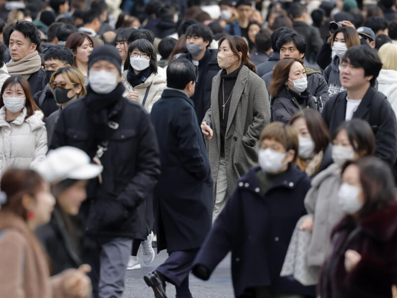 圖為東京澀谷有民眾戴著口罩走在街上。（共同社）