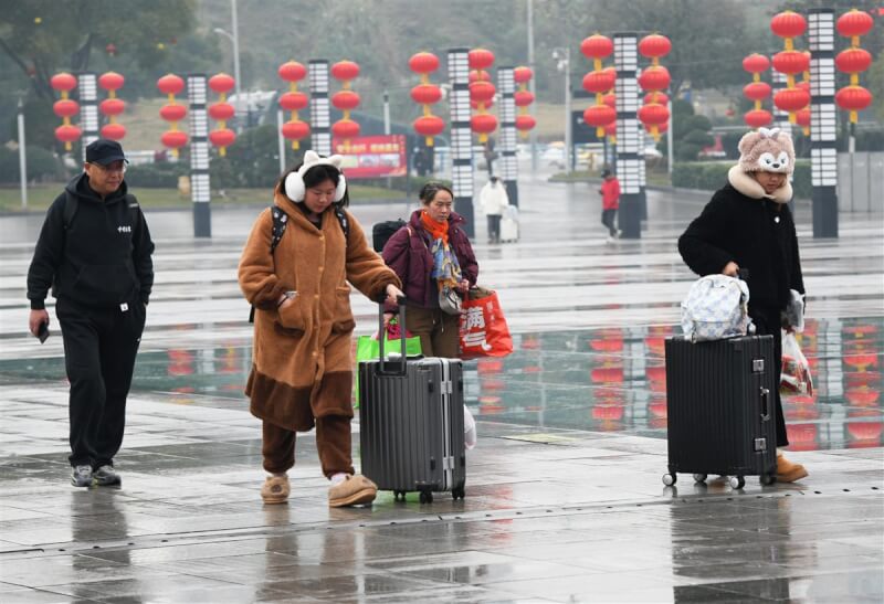 圖為1月14日重慶火車北站北廣場上，旅客帶著行李踏上回家路。（中新社）