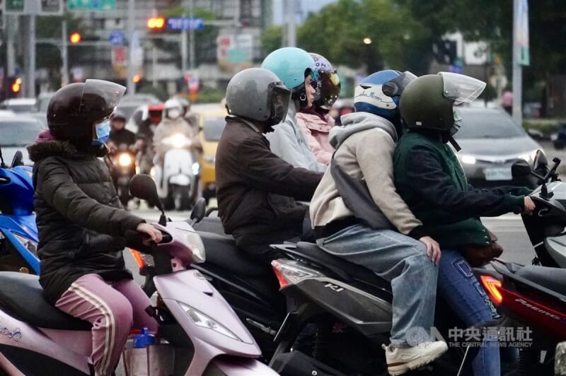 圖為高雄街頭機車騎士穿保暖外套騎車。（中央社檔案照片）