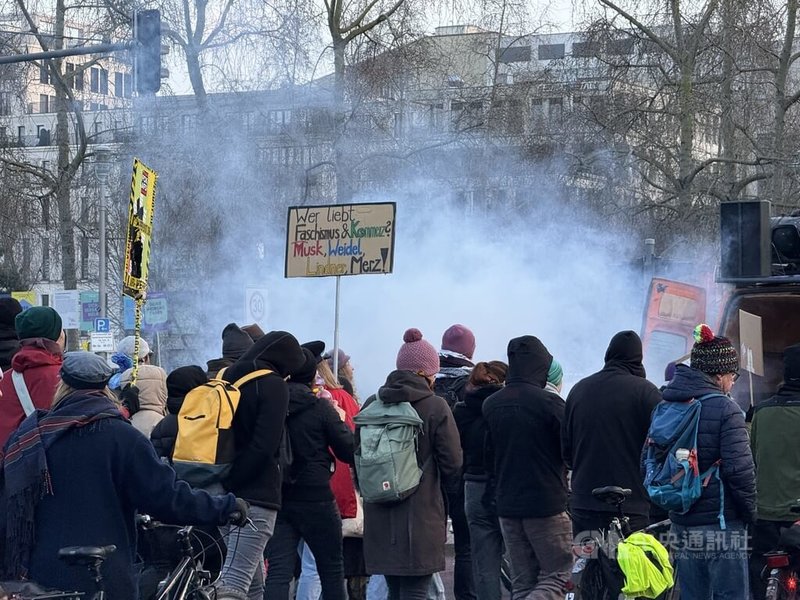 德國柏林9日再度爆發示威活動，遊行抗議標語指億萬富豪馬斯克、德國保守派政治人物梅爾茨與林德納等人與另類選擇黨主席韋德爾同流，並以煙霧模擬火災現場，表示他們對右翼危害民主防火牆不滿。中央社記者林尚縈柏林攝  114年2月10日