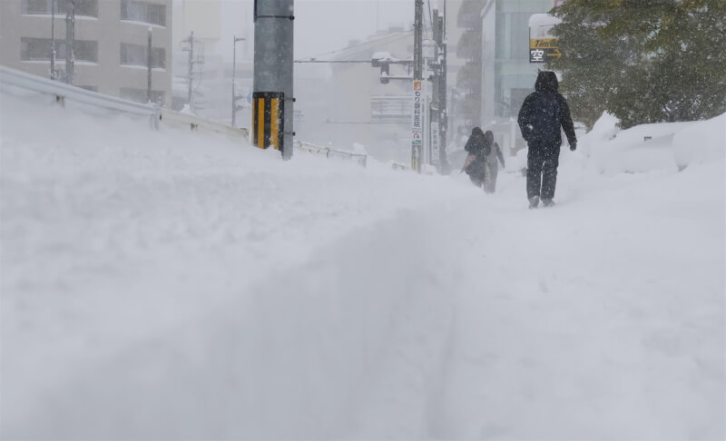 日本多地遭遇本季入冬最強寒流下大雪，圖為8日新潟街道積雪。（共同社）