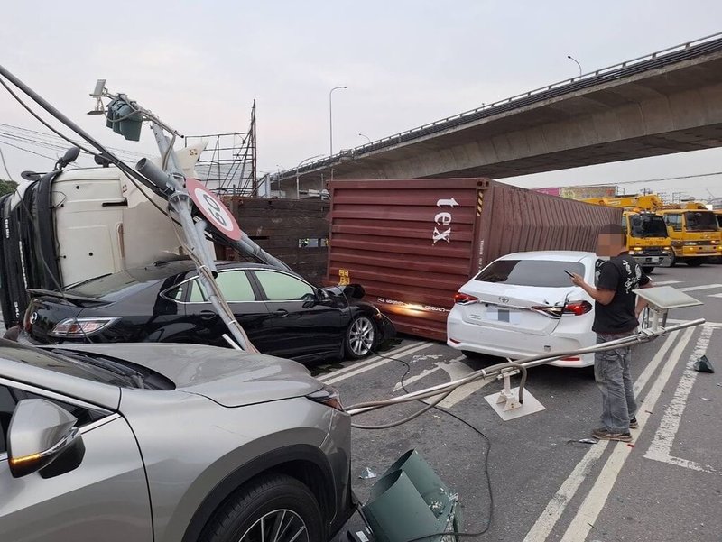 高雄市政府警察局林園分局表示，41歲李姓男子11日下午駕駛大貨車載運貨櫃，自台88快速道路大寮交流道右轉鳳林二路時翻覆，波及3部車輛、2台機車及交通號誌，幸現場無人員受傷受困。（高雄市政府警察局林園分局提供）中央社記者張已亷傳真 114年2月11日