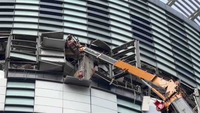 台中新光三越18日出動吊車進行外牆懸掛物拆除作業。（民眾提供）