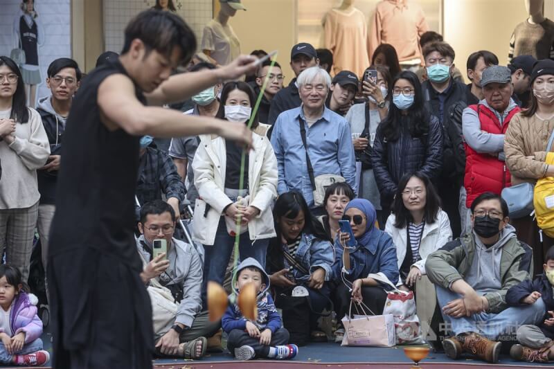 圖為16日台北市西門町許多民眾在路邊欣賞街頭藝人演出。（中央社檔案照片）