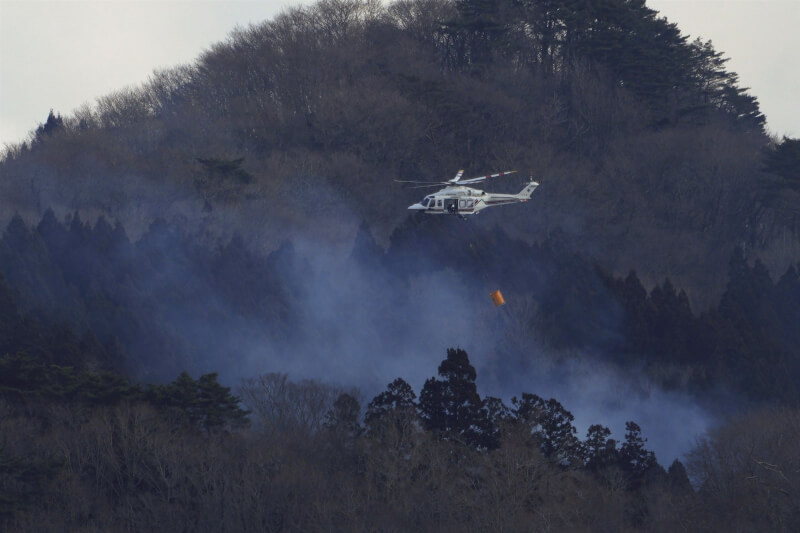 日本岩手縣大船渡市發生山林火災，22日直升機進行灌救。（共同社）