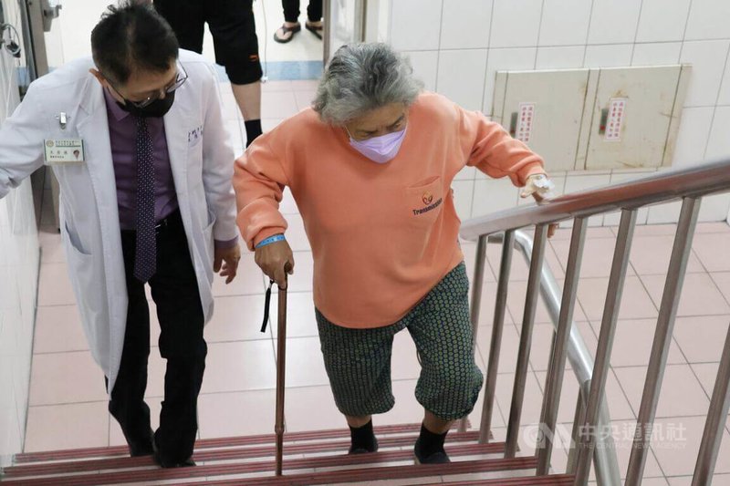 86歲陳姓婦人因退化性關節炎進行人工關節置換，術後恢復良好，大甲李綜合醫院骨科醫師王芳英（左）陪患者爬樓梯復健。中央社記者趙麗妍攝  114年2月26日