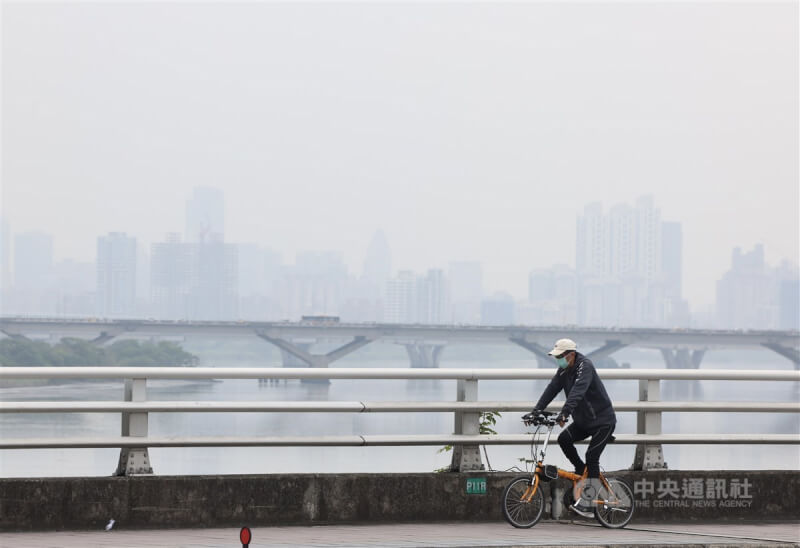 台北市大同區民眾戴口罩騎單車外出。（中央社檔案照片）