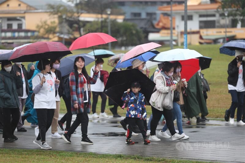 圖為民眾撐傘在台北市花博公園參加健走。（中央社檔案照片）