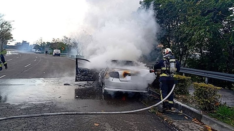 台中市后里區九甲六路和后科路三段口5日下午發生火燒車事件，消防人員前往灌救，年約7旬男性駕駛全身約9成燒燙傷緊急送醫，副駕駛座女性乘客則明顯死亡，起火原因由火調人員調查中。（民眾提供）中央社記者郝雪卿傳真  114年3月5日