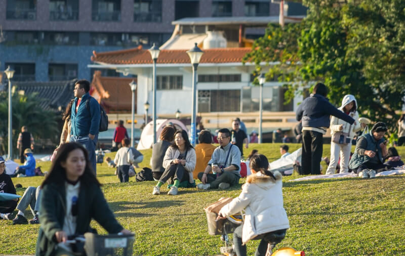 圖為民眾在台北花博公園的草皮上休憩。（中央社檔案照片）