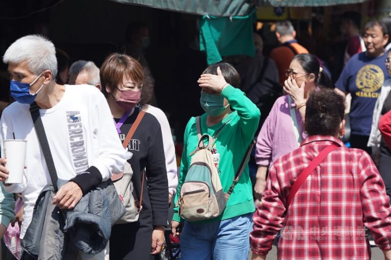 圖為台北市北投區民眾用手遮擋刺眼陽光。(中央社檔案照片)