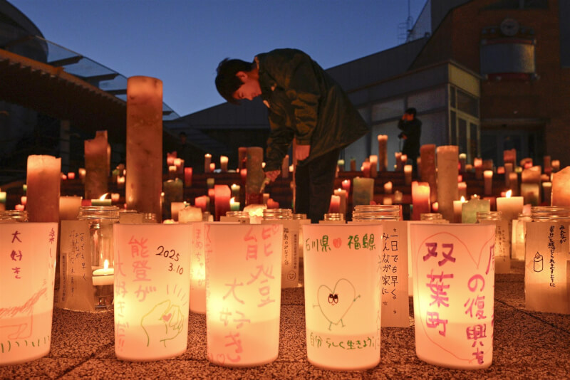 日本福島縣雙葉町10日舉辦的311東日本大地震14週年活動，有民眾在蠟燭上寫下對福島縣的祝福。（共同社）