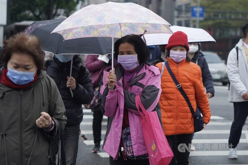 吳德榮表示，13日至16日各地有局部短暫雨，15日起冷空氣將南下。圖為民眾在台北市中山區撐傘過馬路。（中央社檔案照片）