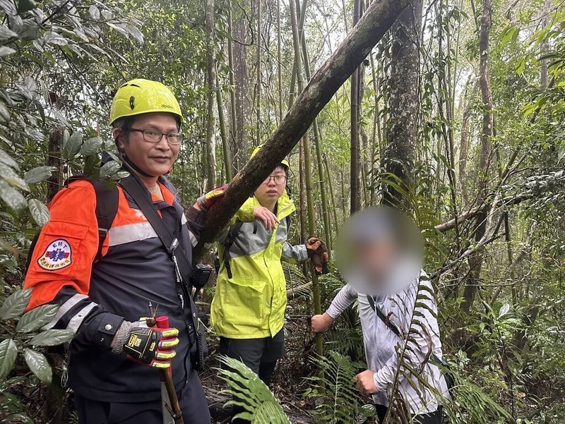 新竹地區今日降雨不斷，63歲劉姓男子（右）15日獨自冒雨攀登新竹縣關西鎮的赤柯山步道，不慎迷失方向報案求助，消防局獲報出動，所幸平安尋獲劉男並引領他至登山口。（新竹縣消防局提供）中央社記者魯鋼駿傳真  114年3月15日