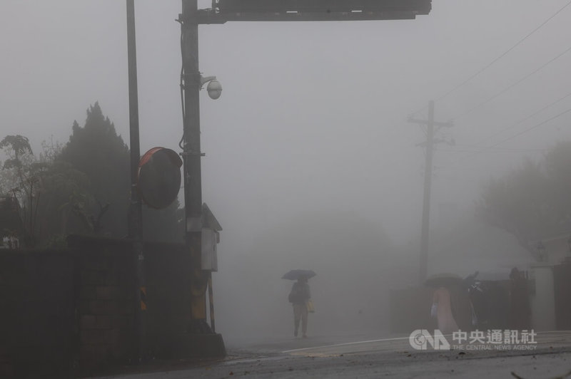 中央氣象署15日清晨發布北台灣7縣市大雨特報，氣象署也預測，下午起強烈大陸冷氣團南下，各地天氣逐漸轉冷。圖為文化大學附近道路起大霧，行人外出撐傘遮雨。中央社記者趙世勳攝　114年3月15日