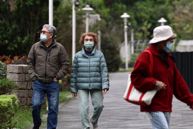 圖為北市中山區花博公園內民眾穿著保暖衣物散步。（中央社檔案照片）