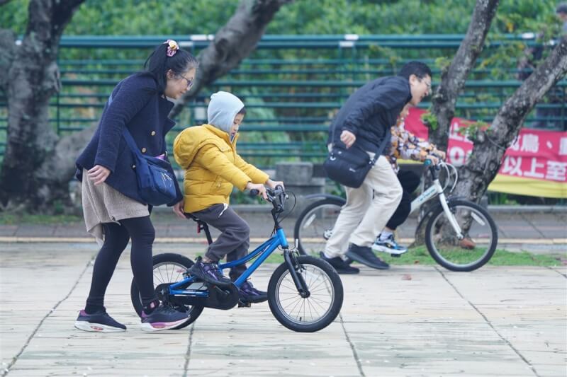 圖為小朋友穿著外套在台北市關渡宮前廣場學騎腳踏車。（中央社檔案照片）