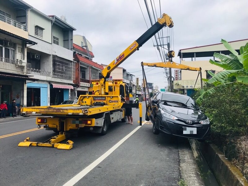 69歲鍾姓女子20日上午開車到高雄市旗山區中興路一段購物，下車時忘記拉起手煞車，造成車輛緩慢滑動並橫越雙向車道，最後掉入水溝，幸未造成人員傷亡。警方到場協助排除狀況。（高雄市警察局旗山分局提供）中央社記者張已亷傳真  114年3月20日