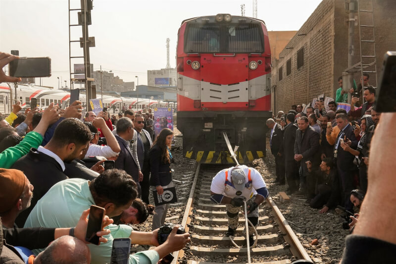 埃及摔角選手馬魯斯 （中）13日在開羅市中心拉姆西斯火車站鐵軌上，創下拉動最重火車頭記錄。（美聯社）