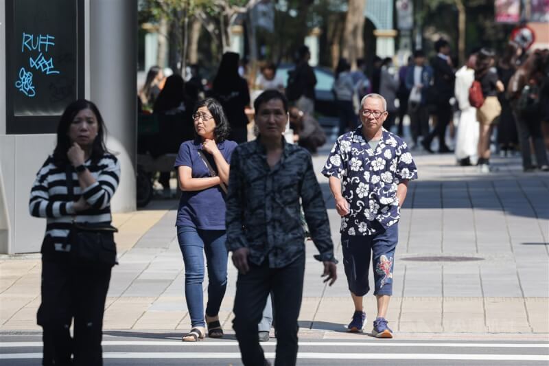 圖為台北市信義區下午晴熱如夏,民眾穿著短袖外出。(中央社檔案照片)