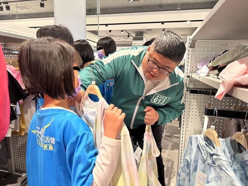 民進黨立委蔡易餘(右)攜手高雄市清景麟教育基金會,30日在嘉義縣朴子市舉辦弱勢兒童購衣公益活動,陪伴孩童在店內挑選喜歡的服飾。(蔡易餘服務處提供)中央社記者黃國芳傳真 114年3月30日