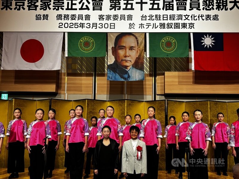 日本具歷史規模的客家僑團「東京崇正公會」30日在東京舉辦第55屆懇親大會,國立客家兒童合唱團在會中獻唱客家歌謠,活潑生動的演出博得滿堂彩。指揮彭孟賢(左)、客委會主委古秀妃與兒童合唱團團員合影。中央社記者戴雅真東京攝 114年3月30日