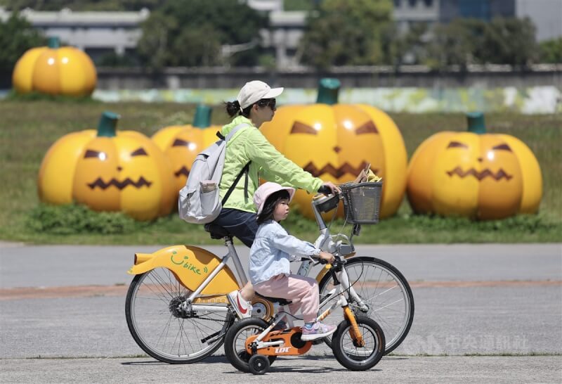 圖為家長帶著小朋友在台北市河濱公園騎腳踏車。(中央社檔案照片)