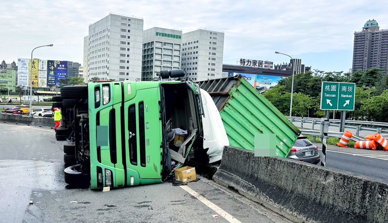 國道公路警察局第一公路警察大隊表示，勤務指揮中心於2日11時17分許接獲通報，國道1號桃園交流道南向環道入口內，有1輛營業半聯結車翻車事故，立刻調派巡邏車前往處理，警消到場後駕駛1人已脫困，隨後送醫診治。（國道公路警察局提供）中央社記者吳睿騏桃園傳真  114年4月2日