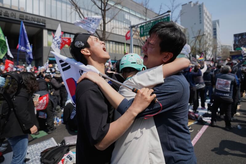 希望通過彈劾案的韓國街頭集會群眾4日在得知總統尹錫悅遭免職下台後高聲歡呼、相互擁抱。(美聯社)